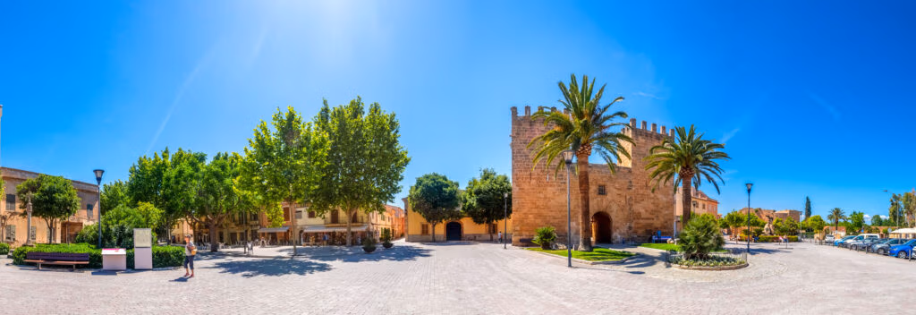 Blick auf Alcúdia auf Mallorca mit Altstadtmauern und Sandstrand